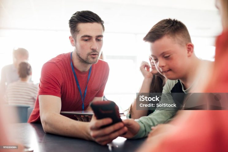 Man demonstrating a mobile to a boy